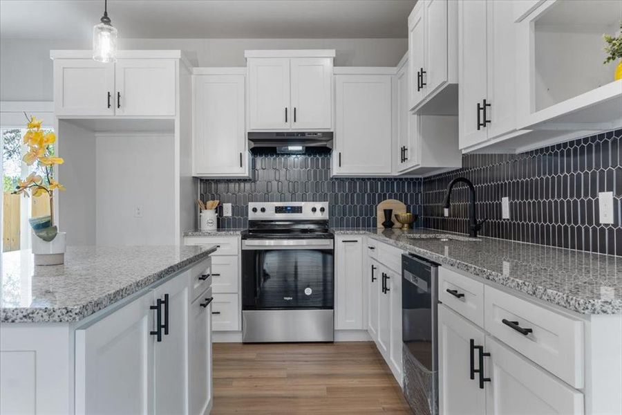 Kitchen featuring hardwood / wood-style flooring, stainless steel appliances, backsplash, and sink