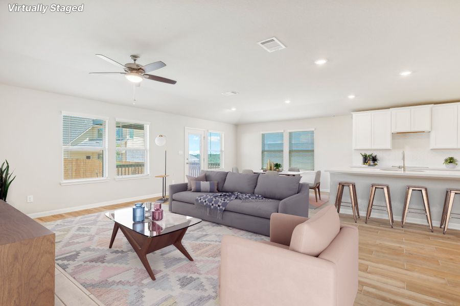 Virtually staged living room and kitchen in the Fitzhugh floorplan at a Meritage homes community.