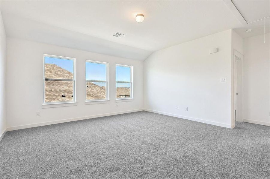 Empty room with lofted ceiling and carpet