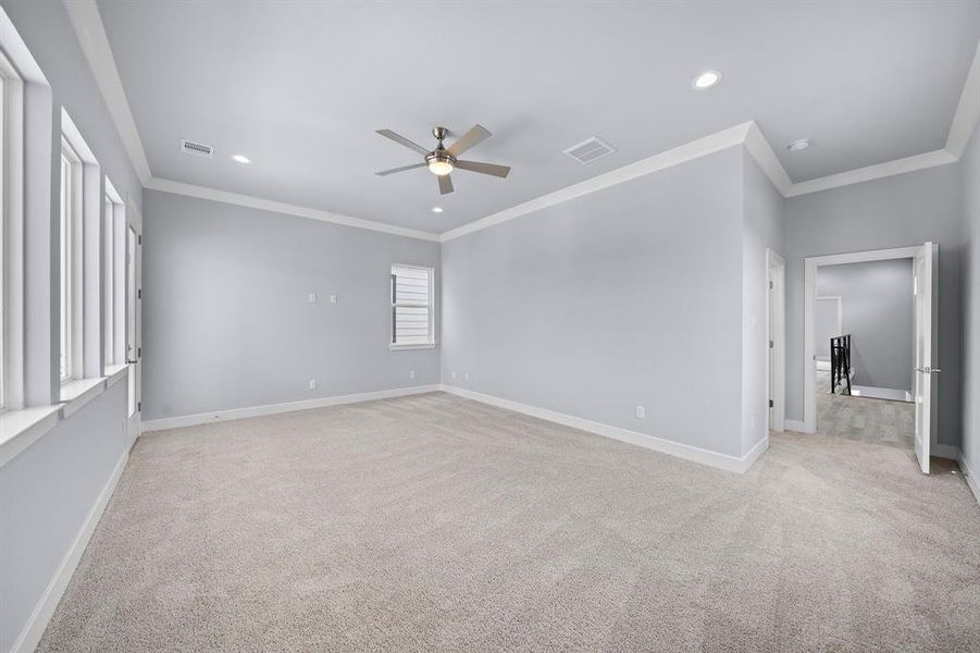 Expansive 21x21 primary bedroom with crown molding and abundant natural light.