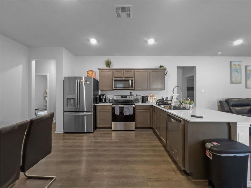 Kitchen with stainless steel appliances, dark wood-type flooring, and sink