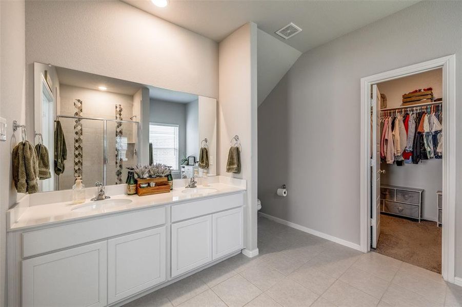 Bathroom with walk in shower, vanity, tile patterned flooring, and toilet