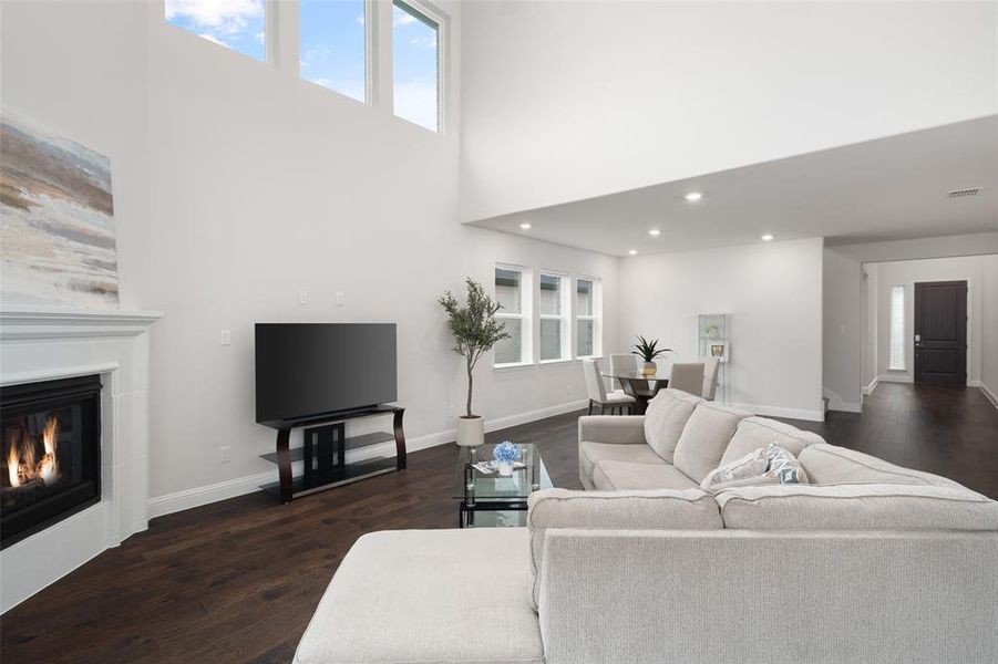 Living room with dark hardwood / wood-style floors and a towering ceiling