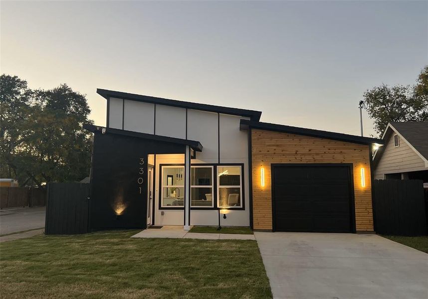 Contemporary home with a garage and a lawn