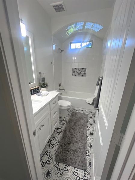 Full bathroom featuring tiled shower / bath combo, tile patterned flooring, vanity, and toilet