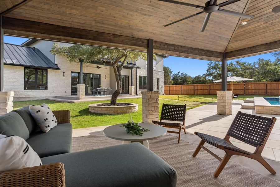 Scenic views from the outdoor living room overlook the beautifully designed home, creating a seamless indoor-outdoor connection.