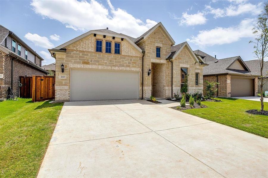 View of front of home with a garage and a front lawn