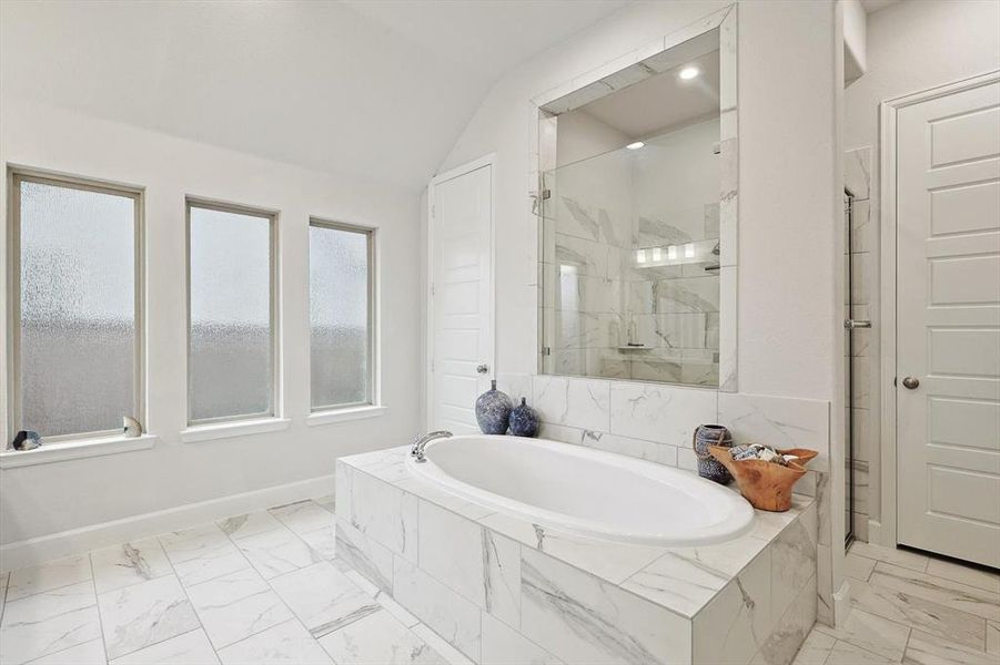 Bathroom with vaulted ceiling and shower with separate bathtub