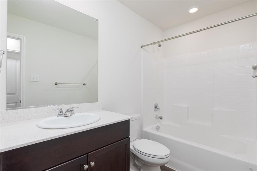 Full bathroom featuring oversized vanity, toilet, and tub / shower combination