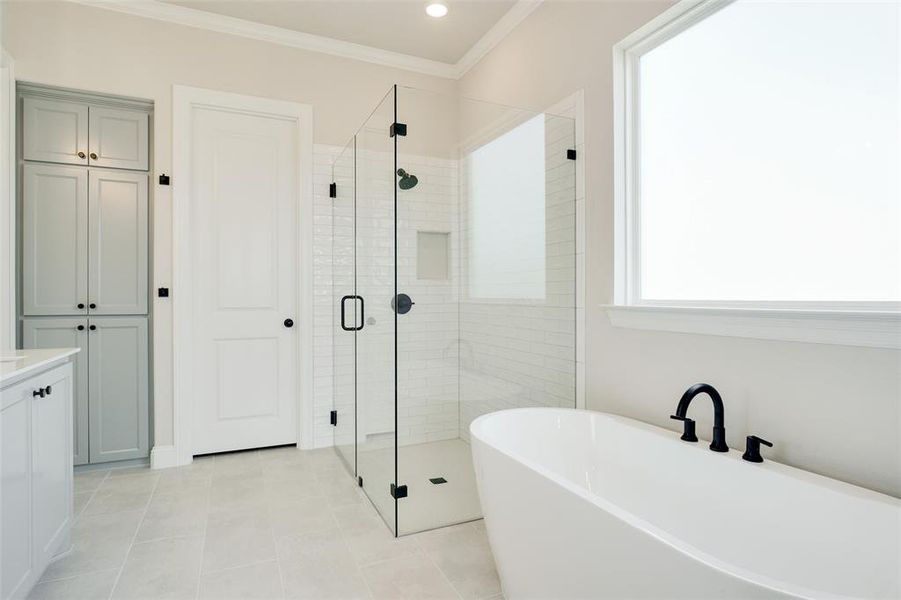 Bathroom featuring tile patterned flooring, independent shower and bath, vanity, and ornamental molding