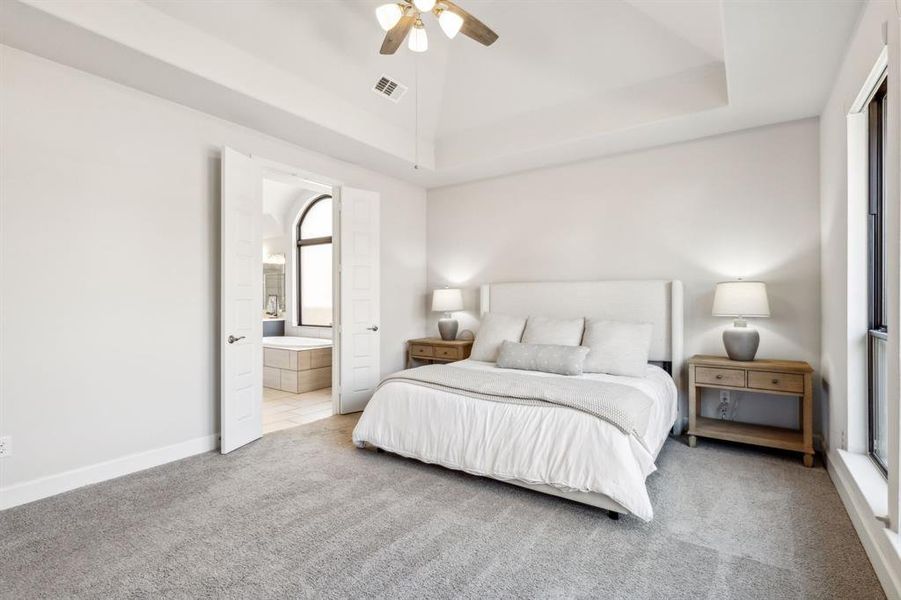 Bedroom with carpet, connected bathroom, and ceiling fan