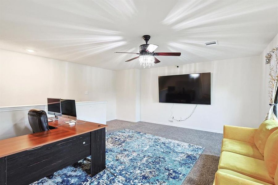 Office area with carpet floors and ceiling fan