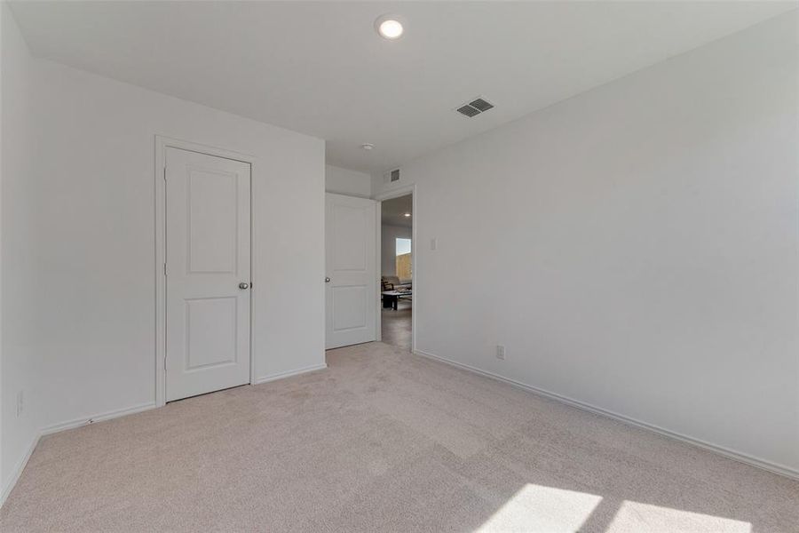 Unfurnished bedroom with light carpet