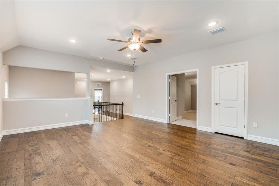 Spare room with lofted ceiling, wood-type flooring, and ceiling fan