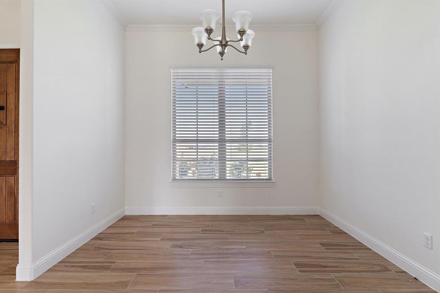 Unfurnished dining area with crown molding and an inviting chandelier