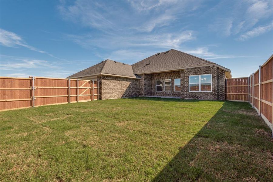 Back of property featuring a lawn