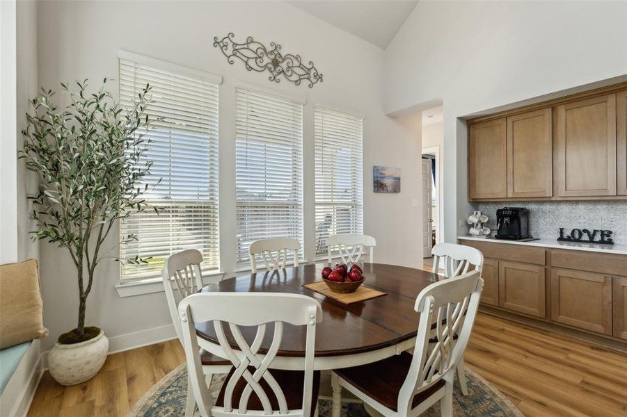 Spacious dining room with window seat and built in butler pantry serving bar and cabinets.