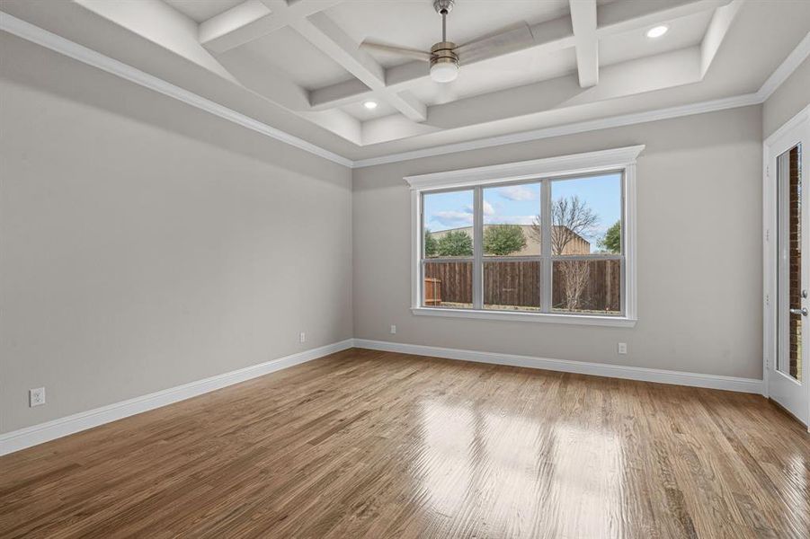 Spare room featuring ornamental molding, ceiling fan, coffered ceiling, and hardwood / wood-style flooringNot actual home. Previous built example..