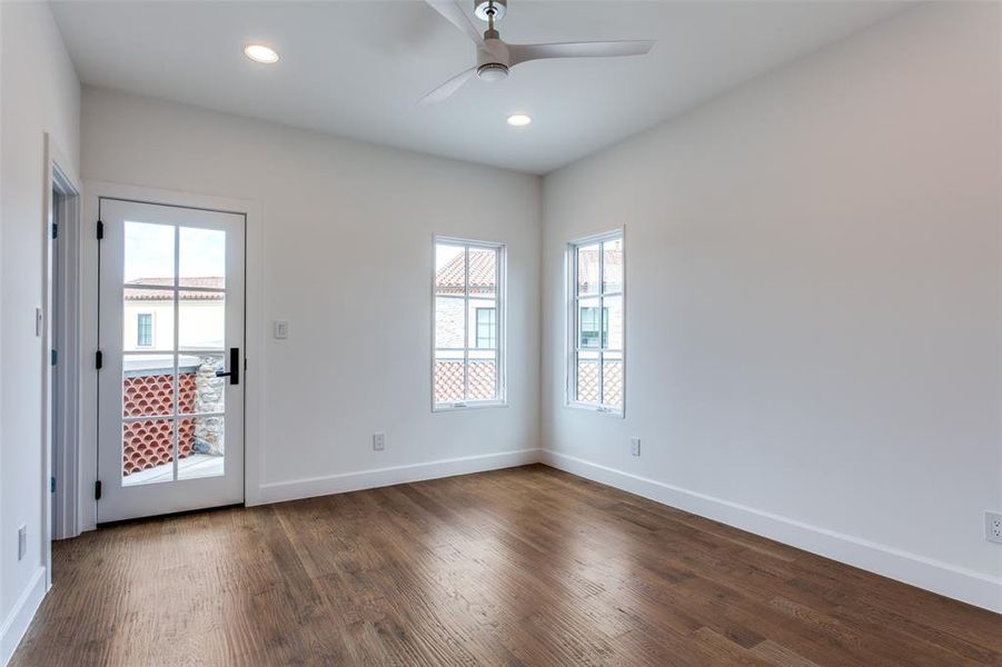 Empty room with dark hardwood / wood-style floors and ceiling fan