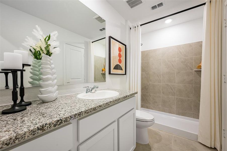Bathroom featuring vanity, tile patterned floors, and toilet