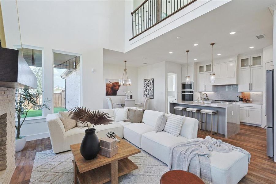 Living room featuring a fireplace, dark hardwood / wood-style flooring, a high ceiling, a chandelier, and sink