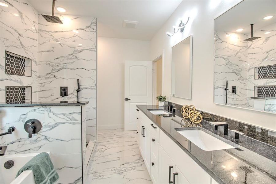 Bathroom featuring tasteful backsplash, tile patterned floors, and double sink vanity