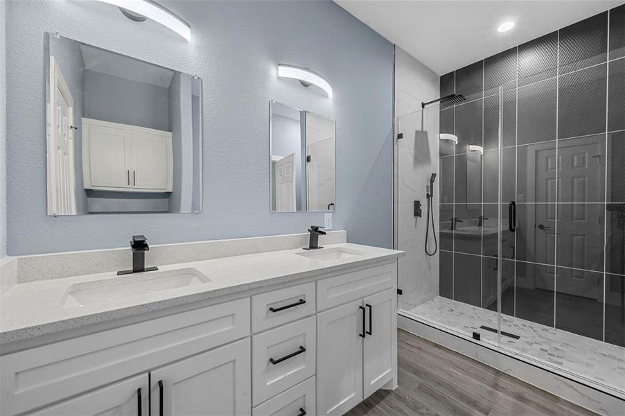 Bathroom featuring vanity, an enclosed shower, and wood-type flooring