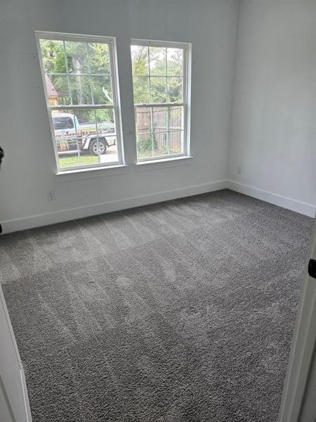 Empty room with carpet flooring and plenty of natural light