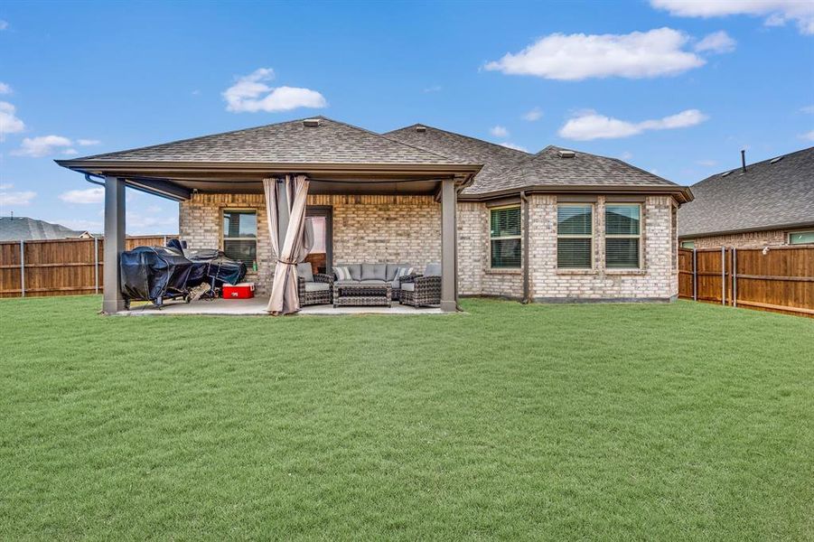 Back of property featuring an outdoor hangout area, a yard, and a patio