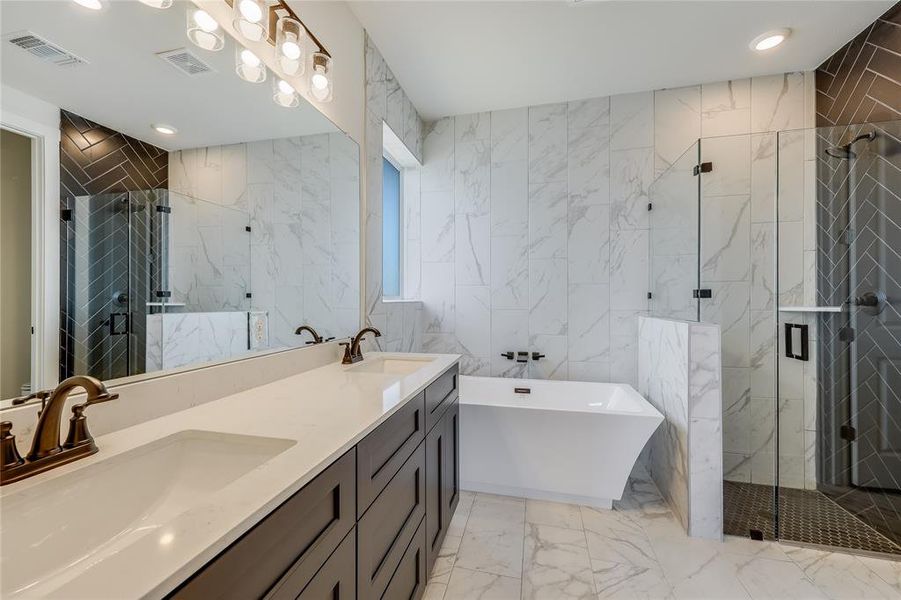 Modern bronze finishes, chevron and penny tile in the shower are just some of the upgrades in this primary bath