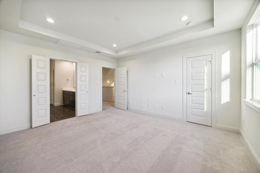 The clean lines of the cabinetry, paired with high-end stainless steel appliances and a pristine marble-patterned backsplash, create a luxurious yet practical kitchen environment. With plenty of counter space and storage, this kitchen is designed for both functionality and elegance.