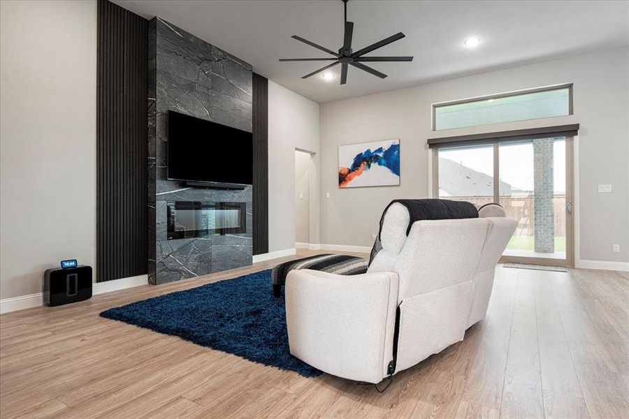 Living room featuring light hardwood / wood-style flooring, a fireplace, and ceiling fan