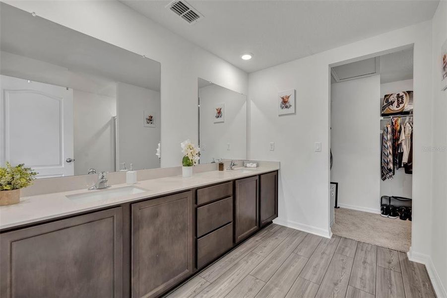 Primary bathroom with double vanity, walk-in shower and huge walk-in closet