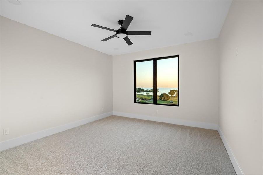 Carpeted empty room featuring ceiling fan