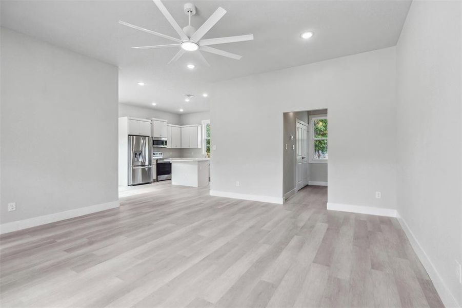 Unfurnished living room with ceiling fan and light hardwood / wood-style flooring