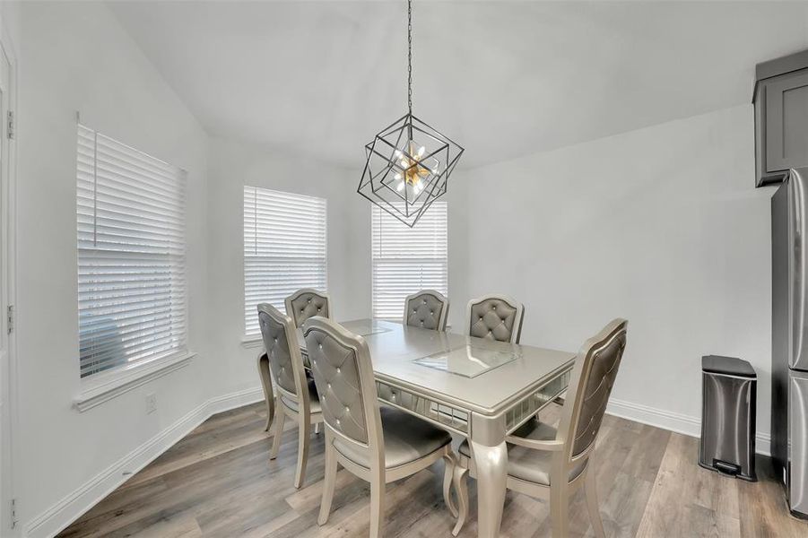 Dining area with light hardwood / wood-style flooring and a chandelier