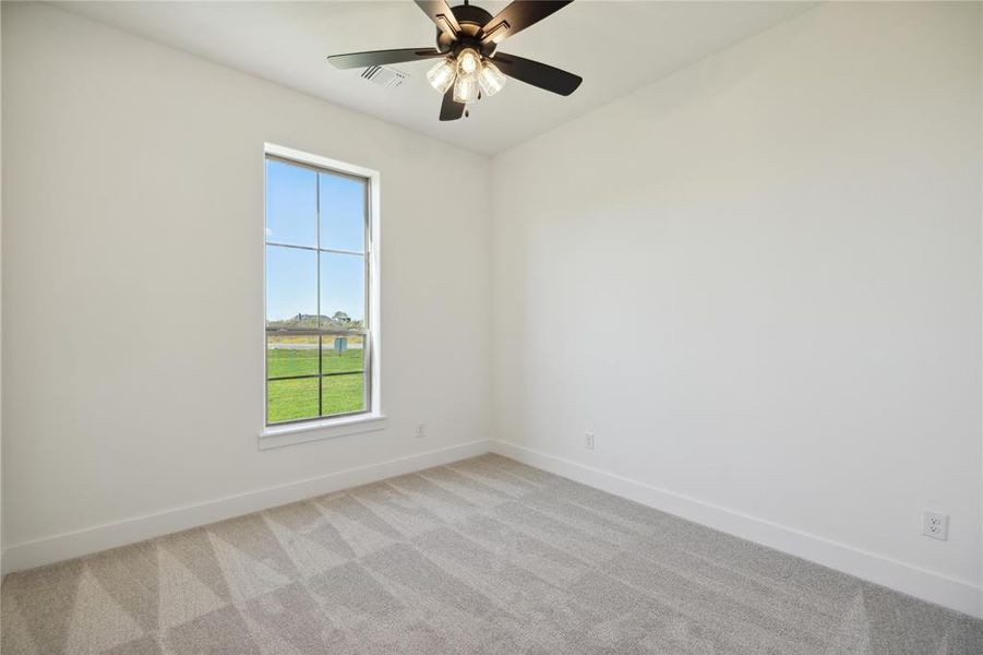 Empty room featuring ceiling fan and light carpet