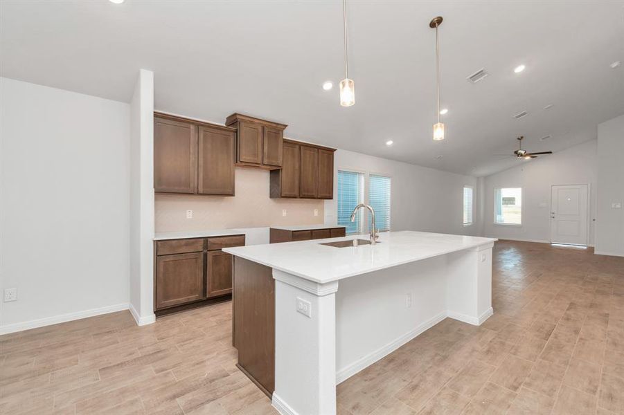 A harmonious blend of open-concept living with a direct line of sight from the spacious kitchen to the bright living area. The elongated layout, enhanced by recessed lighting and a neutral palette, makes this space perfect for both everyday living and entertaining. **This image is from another Saratoga Home - Clover floorplan.**