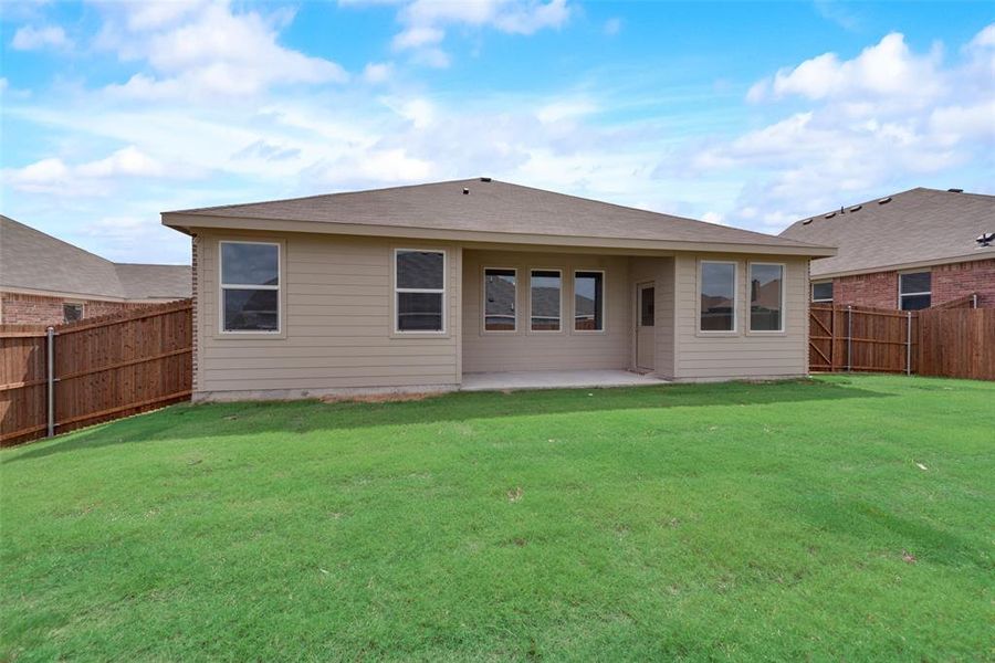 Back of house with a lawn and a patio area