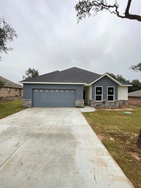 View of front of property with a front yard and a garage