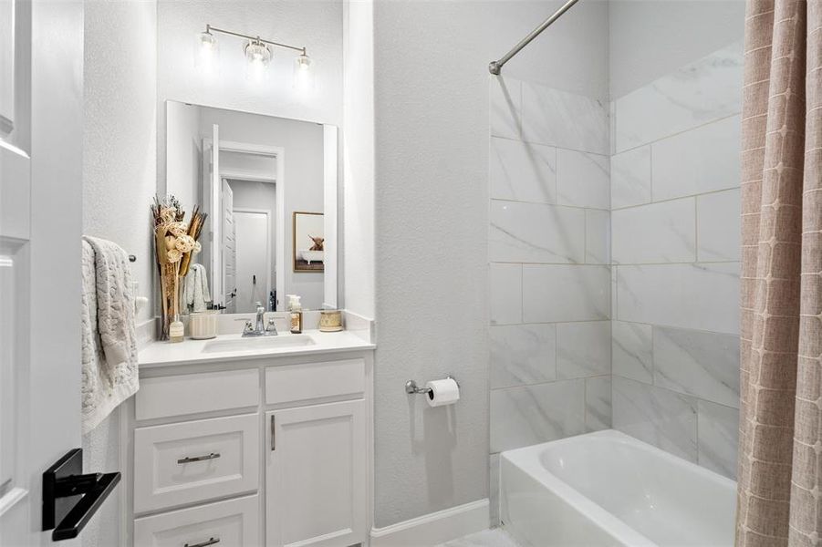 Bathroom featuring shower / bathtub combination with curtain and large vanity