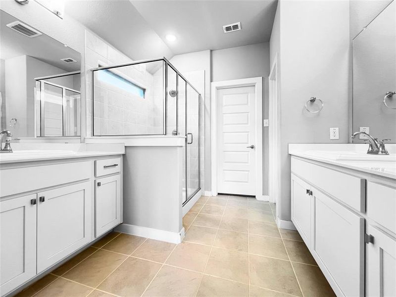 Bathroom with vanity, tile patterned floors, and a shower with door