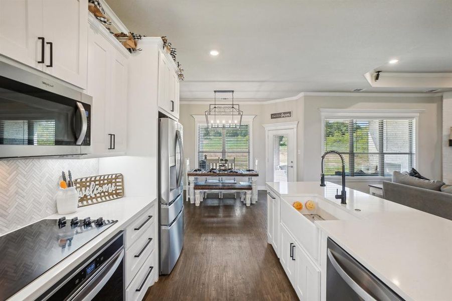 Kitchen featuring pendant lighting, stainless steel appliances, plenty of natural light, and dark hardwood / wood-style flooring