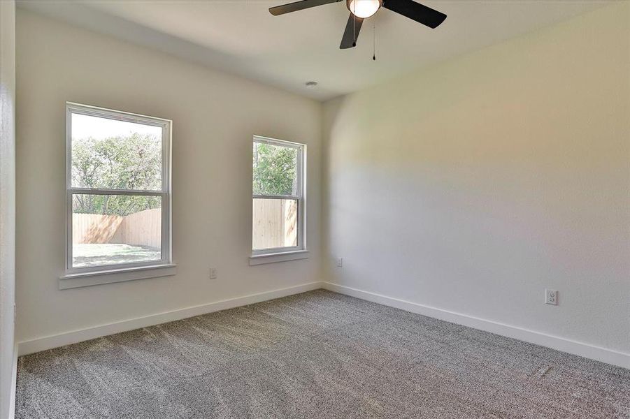 Spare room featuring carpet and ceiling fan