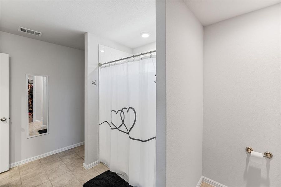 Bathroom featuring walk in shower and tile patterned floors