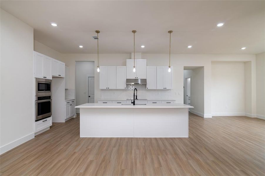 Kitchen featuring appliances with stainless steel finishes, white cabinetry, and light hardwood / wood-style flooring