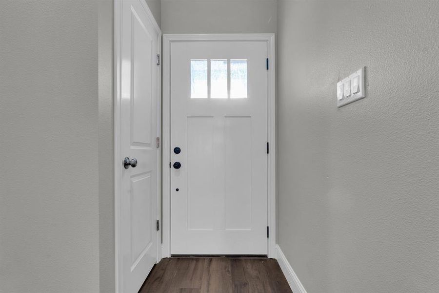 Doorway with dark hardwood / wood-style floors