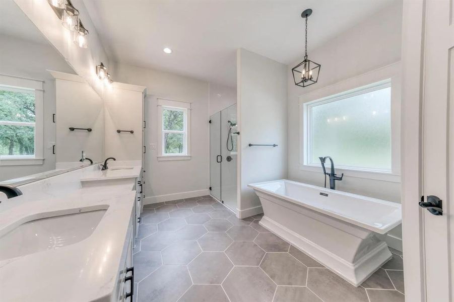 Bathroom with independent shower and bath, vanity, tile patterned floors, and a notable chandelier