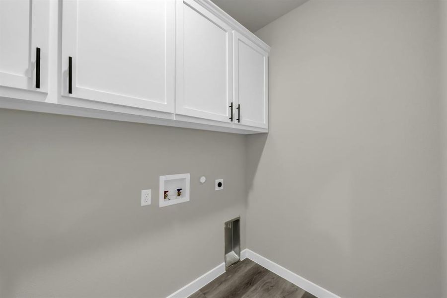 Washroom featuring cabinets, hookup for an electric dryer, hookup for a washing machine, and dark hardwood / wood-style flooring