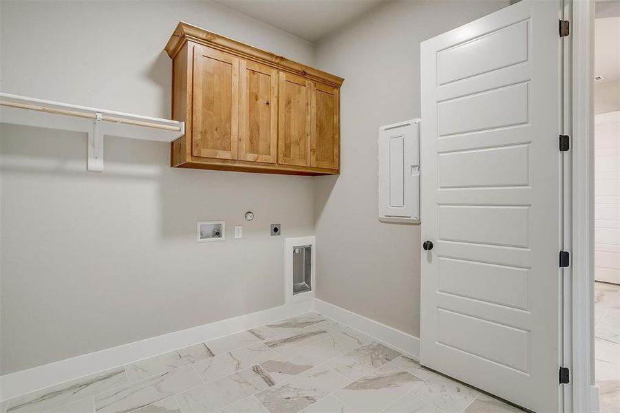 Laundry room with hookup for a gas dryer, cabinets, hookup for a washing machine, light tile floors, and hookup for an electric dryer